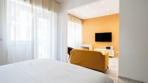 A hotel room with a large bed, a yellow armchair, a TV on the wall, and a small white cabinet. - Saint Nicholas House by Wonderful Italy (Bari)