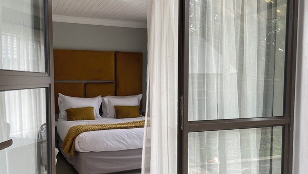 A bedroom with a bed, a headboard, and a window with curtains. - Comfortable Open-Plan Studio Stay — 36 On Blougom, Midrand (Midrand)