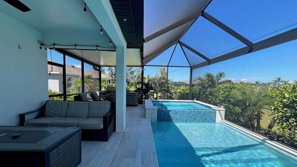 Un espacio exterior cubierto con piscina, mobiliario y vistas del paisaje circundante.