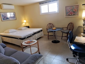 A room with a bed, a small round table with chairs, a sofa, and a desk with a chair. - Apartment 'Villa Roca' with Sea View, Wi-Fi and Air Conditioning (Málaga)