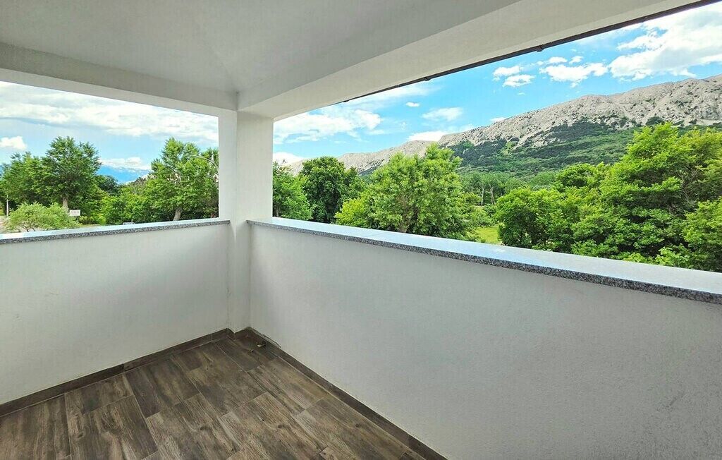 A balcony with a view of green trees and mountains.