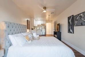 A bedroom with a large bed, a ceiling fan, a TV, and artwork on the wall. - Spacious 5BR Retreat + Game Room (Phoenix)
