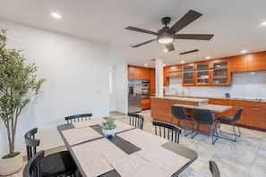 A modern kitchen with wooden cabinets, a built-in oven, and a ceiling fan. - Old Town Living • Walk to Dining, Bars & Fun (Scottsdale)