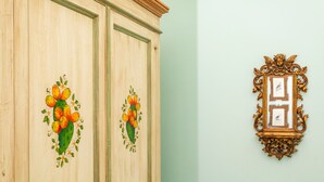 A wooden cabinet with floral carvings and a gold-framed picture on the wall. - Bed and Breakfast 'Luna' with Sea View, Shared Pool and Wi-Fi (Calatabiano)