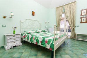 A bedroom with a bed, a nightstand, a dresser, a window with curtains, and wall-mounted lights. - Bed and Breakfast 'Luna' with Sea View, Shared Pool and Wi-Fi (Calatabiano)