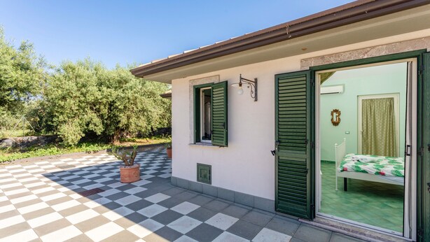 A room with a checkered floor, a bed with a green bedspread, and a window with green shutters. - Bed and Breakfast 'Luna' with Sea View, Shared Pool and Wi-Fi (Calatabiano)