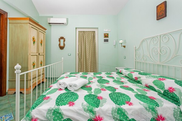 Un dormitorio con cama, armario, puerta y aire acondicionado instalado en la pared.