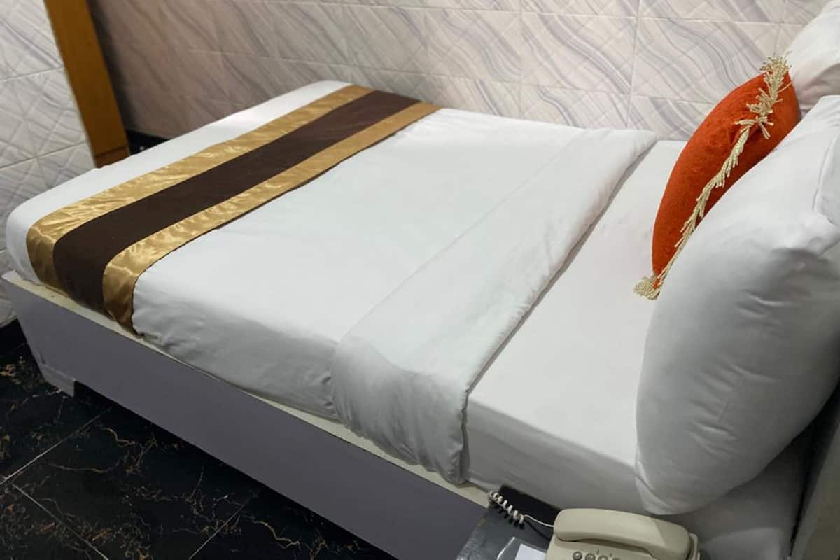 Ein Hotelzimmer mit einem Bett, einem Telefon und einem Marmorboden.