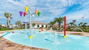 Un parc aquatique avec une piscine, des toboggans et un bâtiment en arrière-plan.
