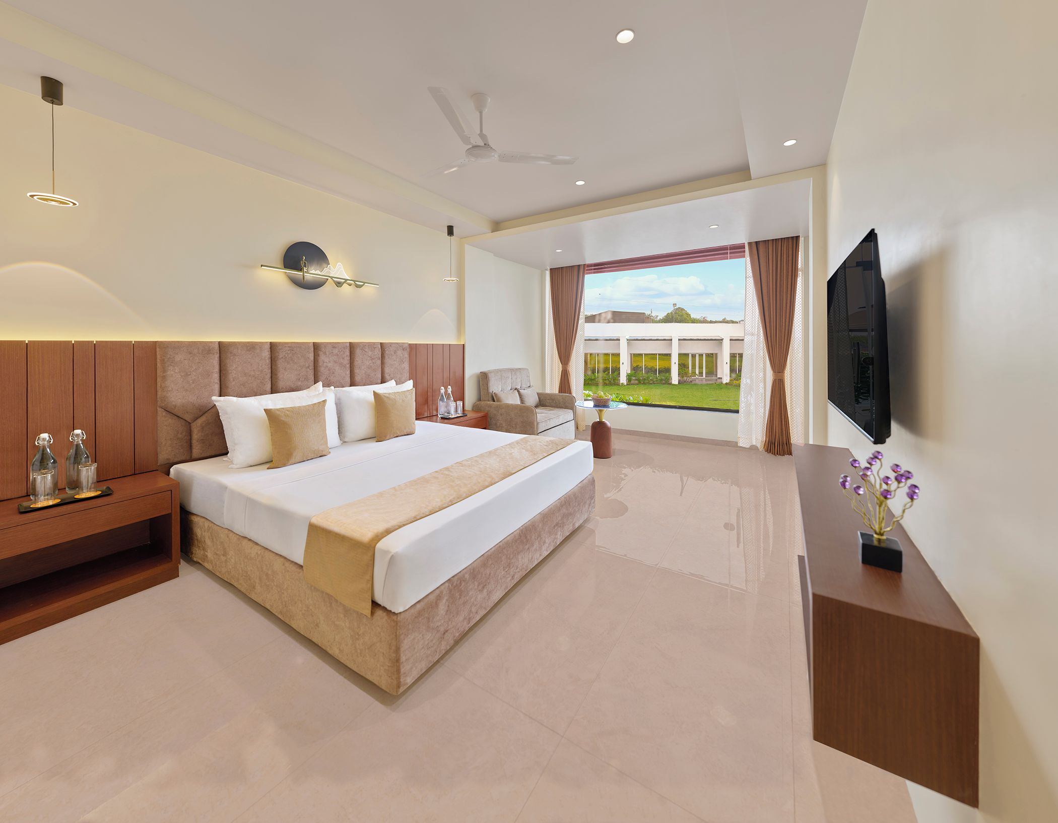 Quarto de hotel moderno com uma cama grande, TV e vista para o exterior.