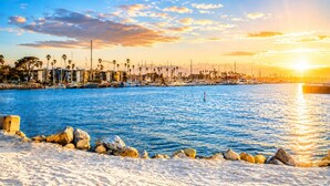 A marina with boats, a sandy beach, and a city skyline in the background. - Walk To Beach, Surfing, Mins 2 Restaurants & Shops (Oxnard)