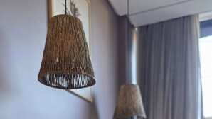 Ένας χώρος τραπεζαρίας με ένα ξύλινο τραπέζι, μπεζ καρέκλες, ένα βάζο με λουλούδια και δύο κρεμαστά φωτιστικά.