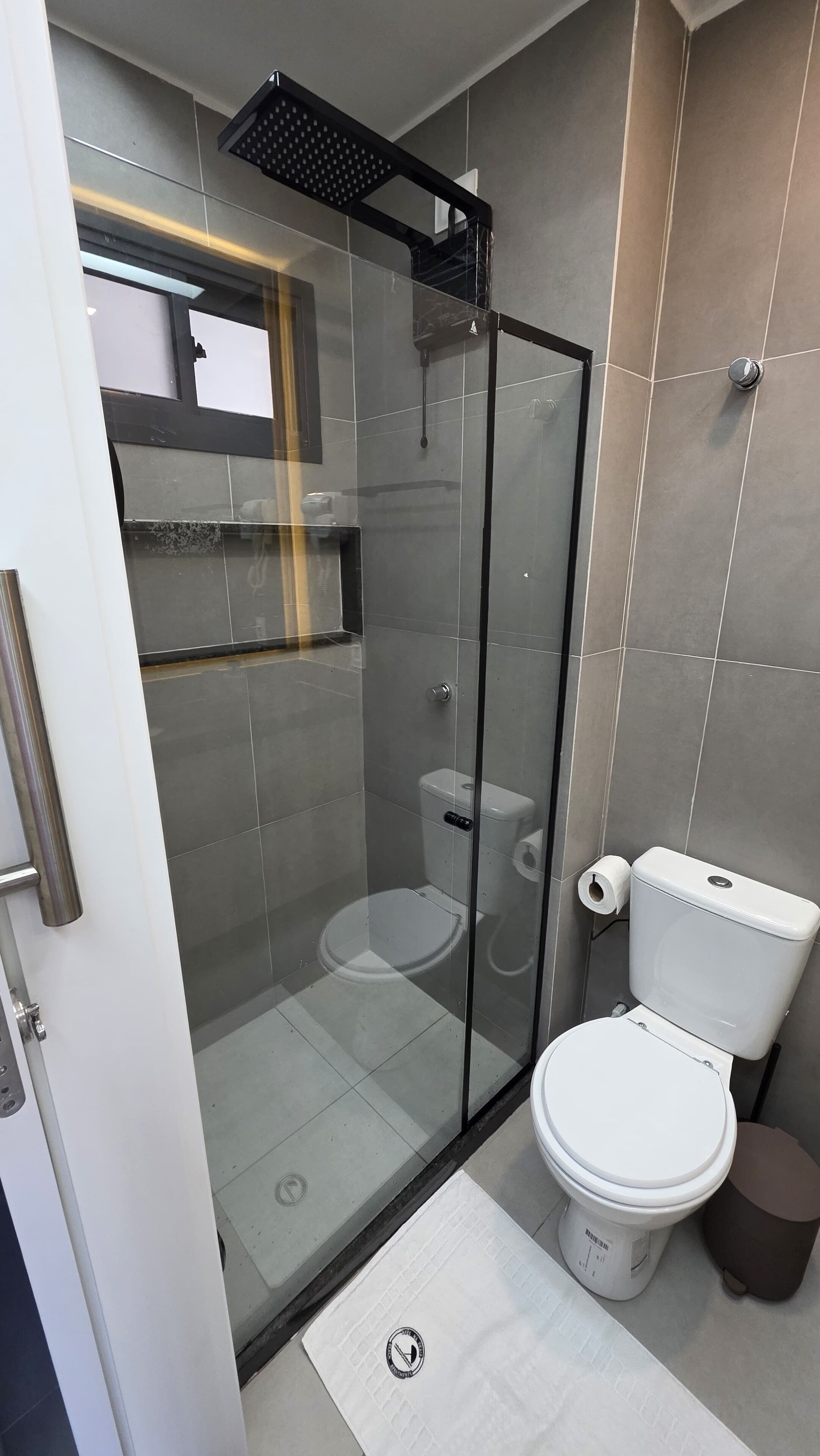 Un baño moderno con cabina de ducha de vidrio, inodoro y bidé.