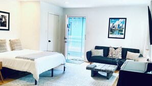 Une chambre d’hôtel moderne équipée d’un lit, d’un canapé, d’une table basse et d’un téléviseur.