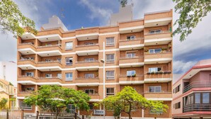 A multi-story brick apartment building with balconies, a sign reading "Tenoric," and a gated entrance. - Living Sol - Centric Urban Room 3 (Santa Cruz de Tenerife)