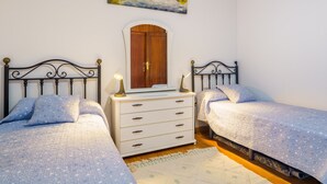 A bedroom with two beds, a dresser, and a painting on the wall. - Living Sol - Centric Urban Room 3 (Santa Cruz de Tenerife)