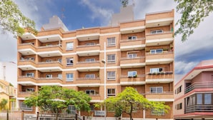 Un edificio de apartamentos de varios pisos de ladrillo, con balcones, un letrero que dice