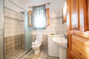 Une salle de bain équipée d’une douche, de toilettes, d’un lavabo et de meubles en bois.