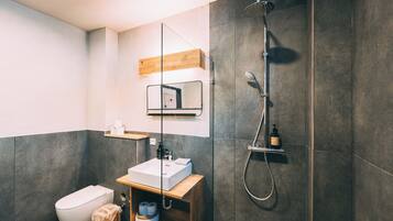 Un baño moderno con ducha, inodoro y lavamanos.