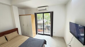 Een slaapkamer met een bed, een kledingkast, een airconditioning en een televisie.