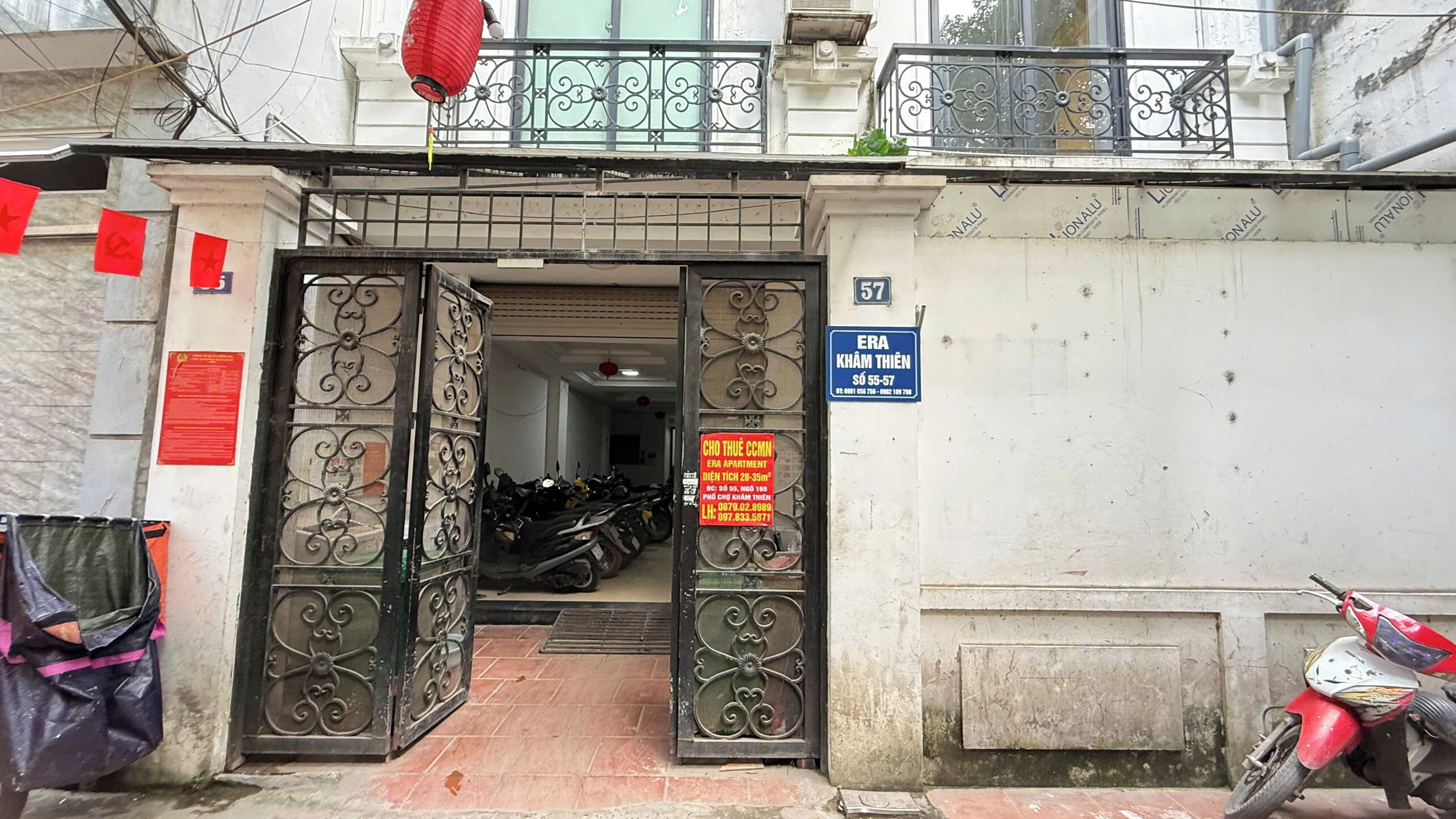 A gated entrance to a building with a sign indicating 'ERA KHAIM THIEN' and a contact number.