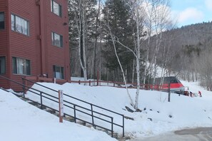 Ein rotes Gebäude mit einer Treppe, die zu einem Parkplatz führt.
