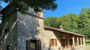 A rustic stone building with a tiled roof, a wooden door, and a small porch area. - House 160 m2 on 6000 m2, sleeps 12 Private garden + shared swimming pool (Espinas)