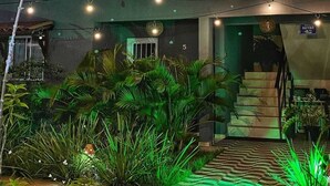 A two-story building with a balcony, string lights, and a staircase. - CHALES DO TOQUE (São Miguel dos Milagres)