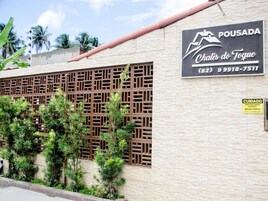 Un edificio con un letrero que dice "POUSADA Chás de Toque (82) 9998-7511".