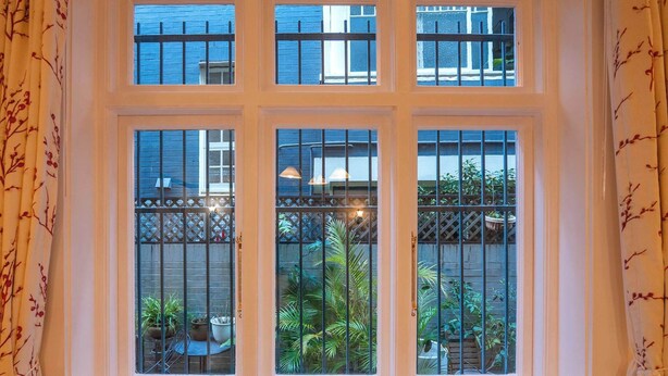 A room with a large window overlooking a garden.