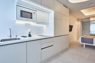 A modern kitchen with a built-in microwave, a coffee machine, and a sink.