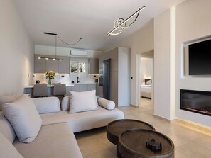 A modern living room with a sofa, coffee table, and fireplace.