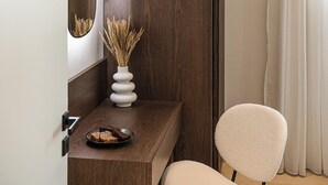 Quarto moderno com escrivaninha de madeira, cadeira branca e espelho.