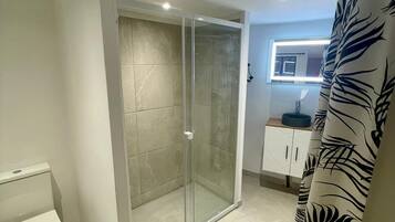 Een douche, handdoeken, zeep, toiletpapier