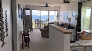 A spacious living area with a balcony, a kitchen with a marble countertop, and a dining area. - Beech Mountain Condo w/ spectacular views & close proximity to hiking and skiing (Beech Mountain)