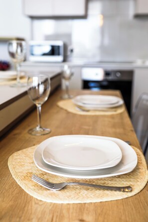 A kitchen counter with a dining setup including plates, a fork, and a wine glass.