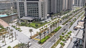 A modern urban hotel with a central courtyard, multiple floors, and a view of the surrounding cityscape.