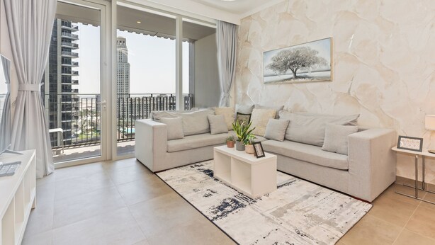 A modern living room with a sofa set, a coffee table, and a painting on the wall.
