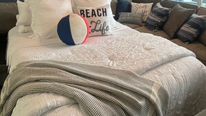 A bedroom with a bed, a ceiling fan, and a window with blinds. - Oceanfront condo with private balcony and unobstructed views -Wildwood Crest (Wildwood Crest)