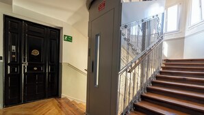 A staircase with wooden steps and a metal railing, leading to an upper floor.