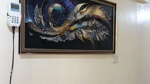 A framed artwork on a wall, a power outlet, and a wall-mounted device. - Cozy and secure 1-bedroom apartment in Juja with WiFi and good views (Juja)