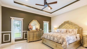 A bedroom with a large bed, a ceiling fan, a dresser, and a window with curtains. - ‼️3BR Getaway Near Everything •Fenced Yard • BBQ (West Palm Beach)
