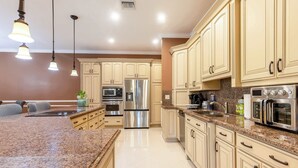 A kitchen with granite countertops, stainless steel appliances, and beige cabinetry. - ‼️3BR Getaway Near Everything •Fenced Yard • BBQ (West Palm Beach)