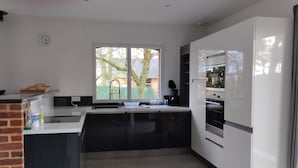 Una cocina moderna con una isla grande, horno empotrado y ventana con vistas al exterior.