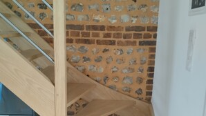 Una escalera de madera con un muro de ladrillo.