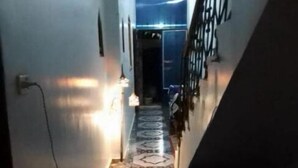 Un couloir au revêtement de sol à motifs menant à un escalier.