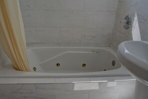 Separate bathtub and shower, towels, soap, shampoo