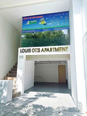 An entrance to Louis Otis Apartment with a signboard advertising Airfresh and various car brands. - LOUIS OTIS APARTMENT 03 (Da Nang)