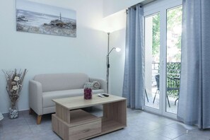 Een moderne woonkamer met een bank, een salontafel, een lamp en een schilderij aan de muur.