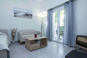 A modern living room with a sofa, coffee table, and a radio. - Sunny 1 Bd Apt in Kallithea with Patio (Kallithea)